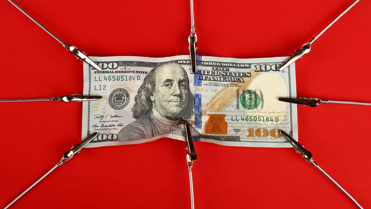 $100 bill being stretched in many directions due to inflation